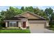 Charming single-story home with a symmetrical facade, red door, and a well-manicured lawn at 4373 Sw 90Th Pl, Ocala, FL 34476