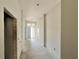 Well-lit hallway showcasing a neutral color palette, smooth walls, and a clear view towards the front entrance at 4373 Sw 90Th Pl, Ocala, FL 34476
