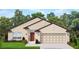 Rendering of a single-story home with a tan exterior, red door, and attached garage at 4429 Sw 90Th Pl, Ocala, FL 34476