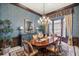 Formal dining room with rich wood tones, chandelier, and large windows at 6861 Sw 179Th Avenue Rd, Dunnellon, FL 34432