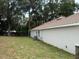 Lush backyard showcasing the home's exterior, with ample space and mature trees, offering both privacy and space at 7 Nw 45Th Loop, Ocala, FL 34470
