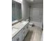 Well-lit bathroom featuring double vanity with granite countertop and a bathtub with shower at 7 Nw 45Th Loop, Ocala, FL 34470