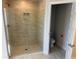 Bathroom showcasing walk-in shower with glass doors and tile surround, with view into toilet area at 7 Nw 45Th Loop, Ocala, FL 34470