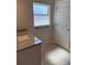 A small bathroom with white trim, stone countertops, luxury vinyl plank flooring, and a frosted window at 7 Nw 45Th Loop, Ocala, FL 34470