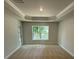 Bright bedroom featuring neutral walls, carpet, trim, and a large window showcasing backyard views at 7 Nw 45Th Loop, Ocala, FL 34470