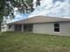 A lawn and the rear view of a single story home with windows, a brown roof, and tan colored stucco at 7 Nw 45Th Loop, Ocala, FL 34470