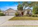 Single story house with three car garage, mature landscaping, and palm trees at 7316 Sw 94Th Ct, Ocala, FL 34481