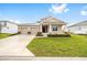 Inviting home featuring a well-maintained lawn, two-car garage, and covered porch at 7884 Sw 59Th St, Ocala, FL 34474