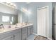 Double vanity bathroom with a large mirror and grey cabinets at 8120 Sw 56Th Ter, Ocala, FL 34476