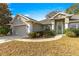 Front view of a single-story house with a teal front door and landscaping at 8120 Sw 56Th Ter, Ocala, FL 34476