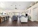 Open living room with hardwood floors, gray sofas, and a view of the kitchen at 8120 Sw 56Th Ter, Ocala, FL 34476