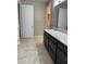 Bathroom featuring granite countertops, dark cabinetry and access to walk-in closet at 9143 Sw 70Th Loop, Ocala, FL 34481