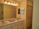 Bright bathroom features a double sink vanity with a large mirror and ample cabinet storage at 9686 Sw 92Nd Place Rd, Ocala, FL 34481