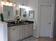 Well-lit bathroom featuring double vanity sinks and white cabinets at 10870 Sw 47Th Ct, Ocala, FL 34476