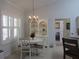 Bright dining area with chandelier, white table, matching chairs and shuttered window at 10870 Sw 47Th Ct, Ocala, FL 34476