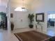 Inviting foyer showcasing tile flooring, a decorative rug, and an arched transom window at 10870 Sw 47Th Ct, Ocala, FL 34476