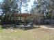 Backyard area with a pergola, seating, and a fire pit, perfect for outdoor entertainment at 10870 Sw 47Th Ct, Ocala, FL 34476