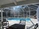 Screened-in pool featuring a dining area, a clear view, and easy access for outdoor enjoyment at 10870 Sw 47Th Ct, Ocala, FL 34476