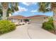 Single-story home with a red tile roof and a large driveway at 11159 Sw 68Th Ct, Ocala, FL 34476