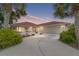 Single-story home with a red tile roof and a large driveway at 11159 Sw 68Th Ct, Ocala, FL 34476