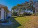 Large backyard with lush grass, mature trees, and a screened patio at 11545 Se 175Th St, Summerfield, FL 34491