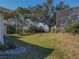 Landscaped backyard featuring a large tree and grassy yard at 11545 Se 175Th St, Summerfield, FL 34491