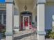 Front porch with red door and white chairs at 11545 Se 175Th St, Summerfield, FL 34491