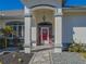 Front porch with red door, stone walkway, and landscaping at 11545 Se 175Th St, Summerfield, FL 34491