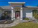 Front porch with red door, stone walkway, and landscaping at 11545 Se 175Th St, Summerfield, FL 34491