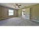 Bright bedroom with ceiling fan, carpet, and door to another room at 12177 Sw 96Th Ln, Dunnellon, FL 34432