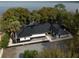 Beautiful exterior shot showcasing the modern design of the home with black roof, surrounding trees and water view at 13061 Se 158Th Ln, Weirsdale, FL 32195