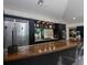 Close-up of the stylish kitchen with stainless steel refrigerator, dark cabinets, and a bar area with seating at 13061 Se 158Th Ln, Weirsdale, FL 32195