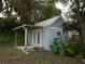 Charming outbuilding with a metal roof and covered porch, set amidst lush greenery at 13061 Se 158Th Ln, Weirsdale, FL 32195