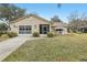 Tan house with double garage and driveway at 1314 Noble Ct, Leesburg, FL 34788