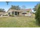 Tan house with screened porch and landscaping at 1314 Noble Ct, Leesburg, FL 34788