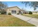 Tan house with double garage and long driveway at 1314 Noble Ct, Leesburg, FL 34788