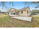 Rear view of tan house, featuring a large patio and sunroom at 1314 Noble Ct, Leesburg, FL 34788