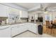 White kitchen cabinets, granite counters, and view into dining area at 1314 Noble Ct, Leesburg, FL 34788