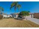 Single-story home with light brown exterior, palm trees, and well-maintained lawn at 13579 Se 89Th Terrace Rd, Summerfield, FL 34491