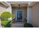 Inviting front entry with a blue door, landscaping, and a bench at 13579 Se 89Th Terrace Rd, Summerfield, FL 34491