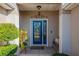 Inviting front entry with a blue door, landscaping, and a bench at 13579 Se 89Th Terrace Rd, Summerfield, FL 34491