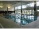 Indoor swimming pool with large windows and seating at 13579 Se 89Th Terrace Rd, Summerfield, FL 34491