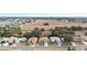 Aerial view of houses on a street with a large open field nearby at 1397 Oak Forest Dr, The Villages, FL 32162