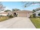 House exterior showcasing a neat lawn and a two-car garage at 1397 Oak Forest Dr, The Villages, FL 32162