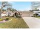 Well-maintained house featuring a large driveway and manicured lawn at 1397 Oak Forest Dr, The Villages, FL 32162