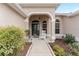 Covered entryway features a rocking chair and well-maintained landscaping at 1397 Oak Forest Dr, The Villages, FL 32162