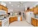 Inviting kitchen features white appliances and warm wood cabinetry at 1397 Oak Forest Dr, The Villages, FL 32162