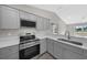 Modern kitchen with stainless steel appliances and gray cabinets at 14898 Se 35 Ct, Summerfield, FL 34491