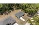 Aerial view of a single-Gathering home with grey roof, set among many trees, with a long driveway at 15304 Sw 27 Ln, Ocala, FL 34481