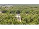 An aerial view of the house with a large wooded area, private residences, and long driveway at 15304 Sw 27 Ln, Ocala, FL 34481